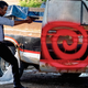 Chris Rock in his cop uniform, pointing a gun at a pickup truck with a pigman inside, for Spiral.